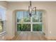 Dining area with a modern light fixture and expansive windows that look out to beautiful natural landscaping at 4777 Duhme Rd # 1A, St Petersburg, FL 33708
