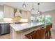 Close-up of a kitchen island featuring marble countertops, stainless steel appliances, and stylish pendant lighting at 4777 Duhme Rd # 1A, St Petersburg, FL 33708