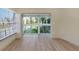 Bright living room with light hardwood floors and large windows overlooking green landscaping at 4777 Duhme Rd # 1A, St Petersburg, FL 33708