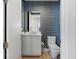 Stylish half-bath with blue wallpaper, modern vanity, and wood-look tile flooring at 5120 Marina Way # 6603, Tampa, FL 33611