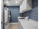 Clean laundry room with a full-size washer and dryer, white counter and blue accent wall at 5120 Marina Way # 6603, Tampa, FL 33611