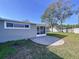 Backyard view featuring a gray house exterior, screened-in porch, and paved patio at 5566 104Th Way, Seminole, FL 33772