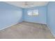 Bright bedroom featuring neutral carpet, a ceiling fan, and a large window for ample natural light at 5980 80Th N St # 410, St Petersburg, FL 33709