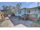A quaint brick backyard patio with a light blue home featuring stairs leading to a deck at 6532 30Th N St, St Petersburg, FL 33702