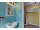 Charming bathroom featuring a pedestal sink, mirror, and bright blue walls at 6532 30Th N St, St Petersburg, FL 33702