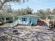 Charming blue home featuring a cozy front porch and a brick driveway with a firepit at 6532 30Th N St, St Petersburg, FL 33702