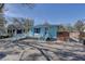 Quaint blue home featuring a cozy front porch and a brick driveway at 6532 30Th N St, St Petersburg, FL 33702