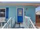 Charming blue house featuring a cozy front porch and blue door at 6532 30Th N St, St Petersburg, FL 33702