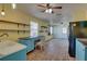 Open kitchen area with wooden floors, blue cabinets, floating shelves and a breakfast bar at 6532 30Th N St, St Petersburg, FL 33702