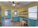 A cozy kitchen area featuring blue cabinets, an open sink, and wooden floors at 6532 30Th N St, St Petersburg, FL 33702