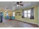 Bright and airy living area with open access to the kitchen featuring floating shelves and wooden floors at 6532 30Th N St, St Petersburg, FL 33702