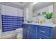 Beautiful bathroom with a blue vanity, gold fixtures, and a stylish mirror at 9347 Blind Pass Rd, St Pete Beach, FL 33706