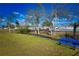 Community green space with a bench, stream, and fenced recreation area in the background, offering a relaxing view at 9987 85Th Way, Seminole, FL 33777