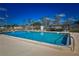 Inviting community pool with clear blue water, surrounded by lounge chairs and a relaxing shaded seating area at 9987 85Th Way, Seminole, FL 33777