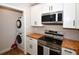 Updated kitchen with stainless steel appliances, butcher block countertops, and stacked washer/dryer at 9987 85Th Way, Seminole, FL 33777