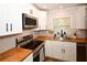 Modern kitchen features stainless appliances, butcher block counters, and bright window at 9987 85Th Way, Seminole, FL 33777