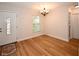 Bright living room showcasing wood flooring, neutral walls, modern lighting, and an entrance door at 9987 85Th Way, Seminole, FL 33777