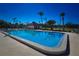 Community pool with clear blue water, surrounded by lush landscaping and a bathhouse on a sunny day at 9987 85Th Way, Seminole, FL 33777