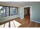 Cozy sunroom featuring wood floors and light-colored walls that leads into an open doorway to a room with wood furniture at 9987 85Th Way, Seminole, FL 33777