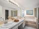 Bright bathroom with double vanity, soaking tub, and glass-enclosed shower, offering a spa-like experience at 1009 Hardwood Dr, Valrico, FL 33596