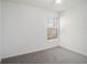 Bedroom featuring neutral carpeting, walls, and a bright window at 1009 Hardwood Dr, Valrico, FL 33596
