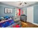 Blue bedroom with hardwood floors, featuring a crib and dresser at 119 W Powhatan Ave, Tampa, FL 33604