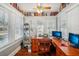 Inviting home office surrounded by shelves, with hardwood floors and lots of natural light at 119 W Powhatan Ave, Tampa, FL 33604