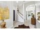 Bright hallway featuring stylish flooring, a staircase, and an art display niche at 12716 Flatwood Creek Dr, Gibsonton, FL 33534