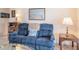 Comfortable living room with a blue sofa, side table with lamp, and decorative wall art at 1409 Coachlight Way, Dunedin, FL 34698