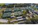 Aerial view of multiple well-maintained tennis courts near a lake and clubhouse, offering a vibrant community amenity at 1509 Blackstone Cir, Sun City Center, FL 33573