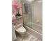 Cozy bathroom with walk-in shower, decorative pink orchid, and matching pink shoe-themed wallpaper at 1522 Gulf Blvd, Indian Rocks Beach, FL 33785