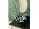Stylish bathroom featuring a unique vessel sink and monstera leaf wallpaper at 1522 Gulf Blvd, Indian Rocks Beach, FL 33785