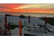 Beach sunset view with patio furniture and beautiful, vibrant colors at 1522 Gulf Blvd, Indian Rocks Beach, FL 33785
