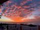 Scenic beach view at sunset with colorful clouds, ocean waves, and beach furniture at 1522 Gulf Blvd, Indian Rocks Beach, FL 33785