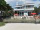 Beautiful beachfront home with palm trees, outdoor seating, and stairs leading down to the sandy beach at 1522 Gulf Blvd, Indian Rocks Beach, FL 33785