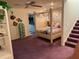 Spacious bedroom with a four poster bed, carpet floor, and staircase leading to another level at 1522 Gulf Blvd, Indian Rocks Beach, FL 33785