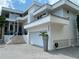 A modern home with a large front-facing garage and beautiful landscaping at 1522 Gulf Blvd, Indian Rocks Beach, FL 33785