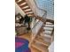 Bright foyer with artistic rug, wood stairs, and decorative chest at 1522 Gulf Blvd, Indian Rocks Beach, FL 33785