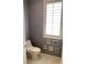 Cozy half bath featuring patterned wallpaper, white fixtures, and natural light from shuttered window at 1522 Gulf Blvd, Indian Rocks Beach, FL 33785