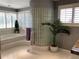 Main bathroom with jetted tub, privacy shutters, and a unique glass block wall at 1522 Gulf Blvd, Indian Rocks Beach, FL 33785