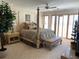Main bedroom features large four-poster bed, shutters, and neutral decor at 1522 Gulf Blvd, Indian Rocks Beach, FL 33785