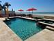 Backyard pool, hottub, and beach access with chairs and umbrellas at 1522 Gulf Blvd, Indian Rocks Beach, FL 33785