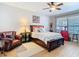 Cozy bedroom features a ceiling fan, wood accents, and a comfortable seating area at 1805 Abbey Trace Dr, Dover, FL 33527