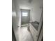 Bright white bathroom with marbled tile, shower, and vanity at 1817 Meridel Ave, Tampa, FL 33612