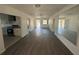 Open living room area with dark wood-look floors, leading into dining and kitchen at 1817 Meridel Ave, Tampa, FL 33612