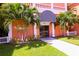 Building entrance featuring manicured landscaping, a black and white awning, and fresh green lawn at 1900 68Th N St # 104, St Petersburg, FL 33710
