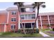 Exterior shot of a condo building with balconies, palm trees, and a manicured lawn at 1900 68Th N St # 104, St Petersburg, FL 33710