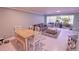 Bright living room featuring a gray couch, soft rug, and access to sunroom with many plants at 1900 68Th N St # 104, St Petersburg, FL 33710