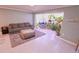 Sunroom featuring a gray couch, soft rug, and access to sunroom with plants at 1900 68Th N St # 104, St Petersburg, FL 33710