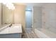 Bathroom featuring a white vanity with marble countertop, a tub, and white marble-style tiles at 2105 Clover Hill Rd, Palm Harbor, FL 34683